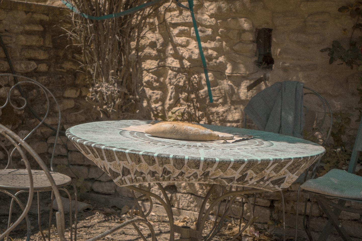 Una hogaza de pan sobre una mesa exterior de mosaico.